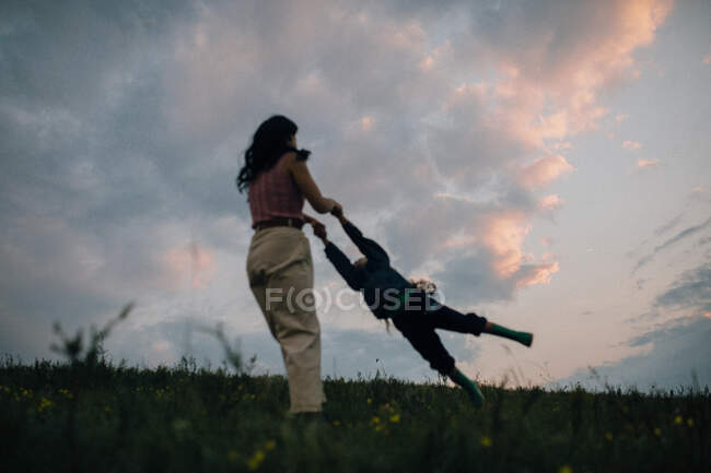 Mamá balanceo niño al aire libre - foto de stock