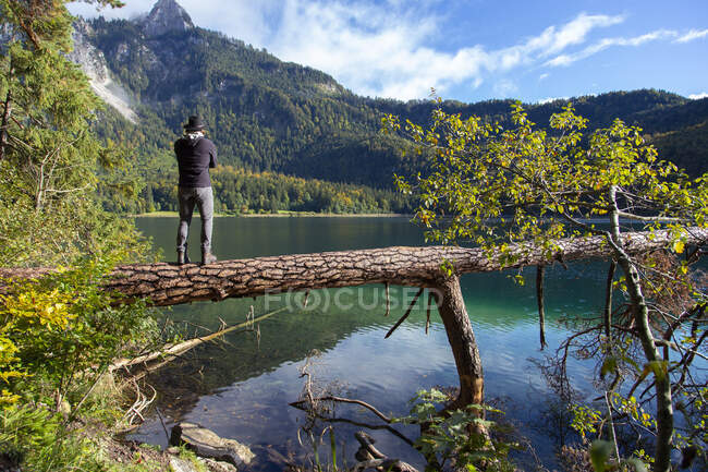 Una persona mirando a través de un lago alpino claro en un día soleado en Alemania - foto de stock