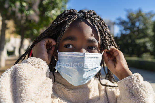 Linda menina africana colocando a máscara — Fotografia de Stock