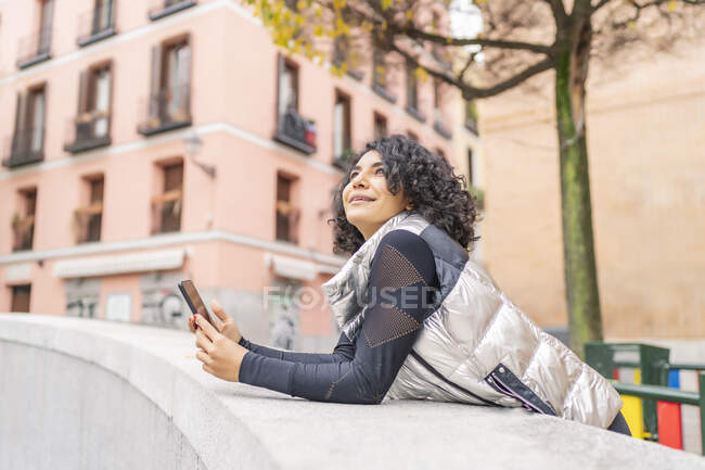 Mujer disfrutando de la ciudad y usando su smartphone - foto de stock