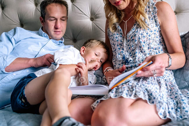 Jeune garçon piquer du nez pendant que maman lui lit une histoire — Photo de stock