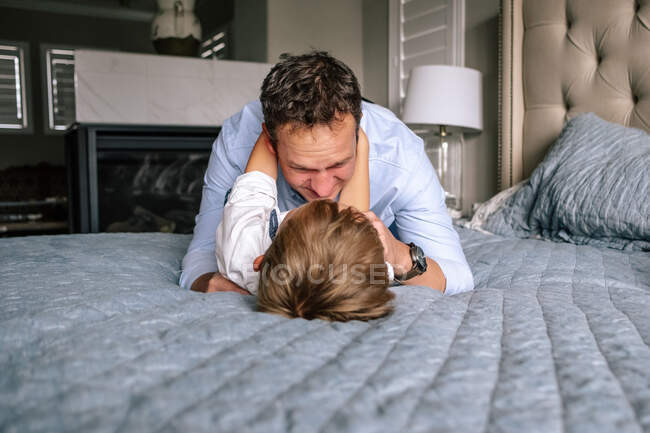 Felice papà e figlio a giocare sul letto — Foto stock