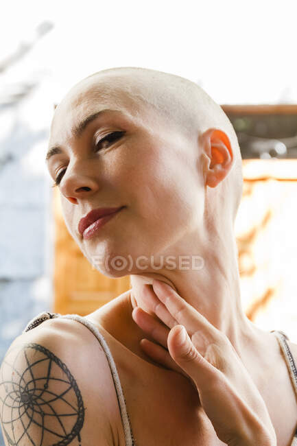 Close-up of young woman with shaved head looking down — Stock Photo