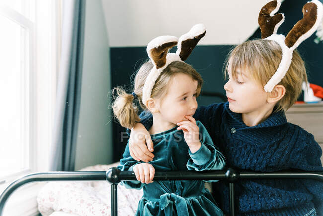 Duas crianças juntas em uma sala falando sobre renas e cláusula de Papai Noel — Fotografia de Stock