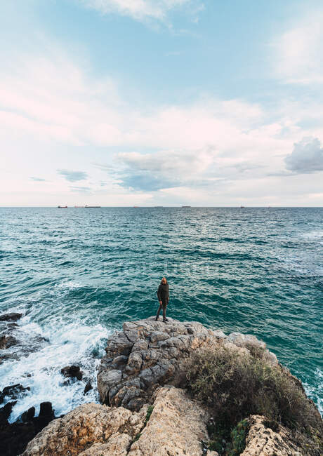 Foto épica de un hombre en el centro de un paisaje frente al mar - foto de stock