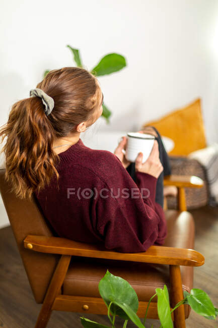 Donna seduta accogliente con la sua tazza — Foto stock