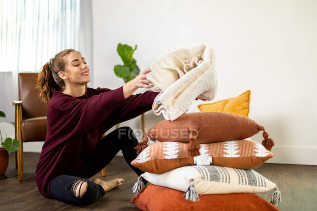 Жінка сидить на підлозі організовує текстиль — стокове фото