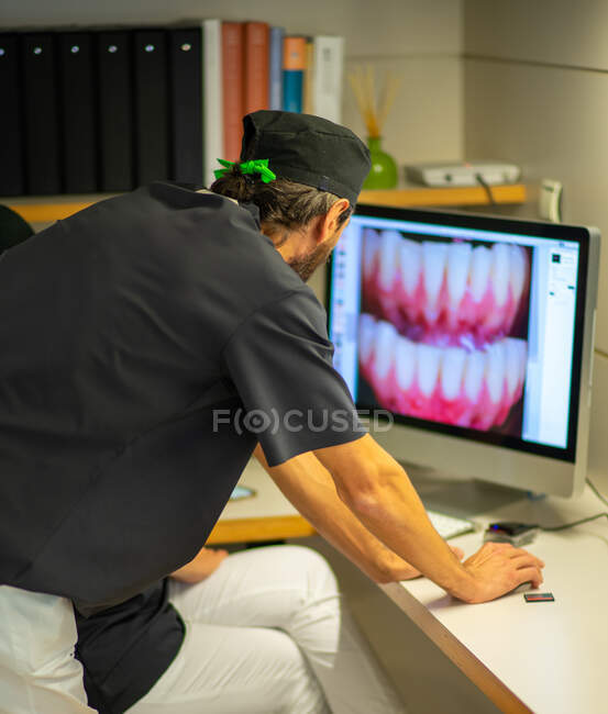 Dentiste vérifiant les photos à la clinique dentaire — Photo de stock