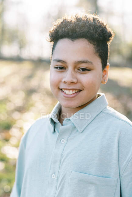 Portrait d'un jeune garçon en plein air souriant dans la caméra — Photo de stock