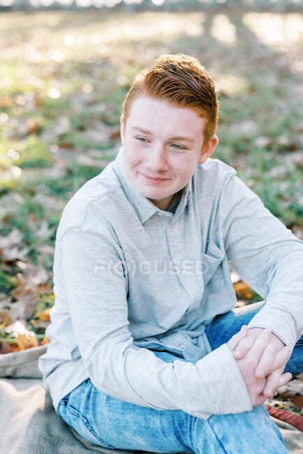 Retrato de cerca de un adolescente con el pelo rojo sonriendo - foto de stock