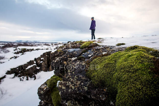 Persona in piedi con rocce e muschio nel Parco Nazionale di Thingvellir — Foto stock