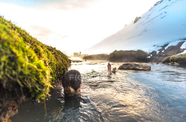 Женщина отдыхает в Рейкьядалуре геотермальная река в Исландии — стоковое фото