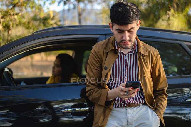 Чоловік користується мобільним телефоном під час подорожі з дівчиною.. — стокове фото