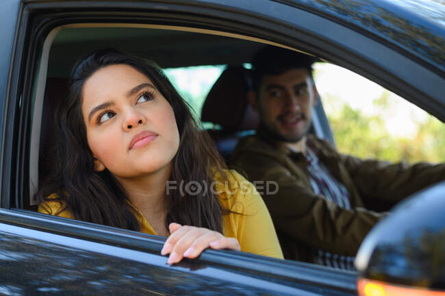 Chica guapa y hombre viajando juntos en un viaje por carretera mientras conducen - foto de stock