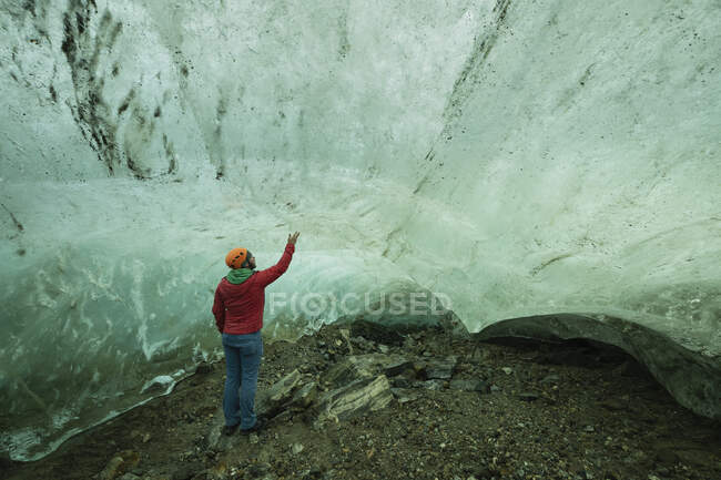Persona que explora la cueva de hielo en el glaciar cerca de Kulusuk, Sermersooq, Groenlandia Oriental - foto de stock