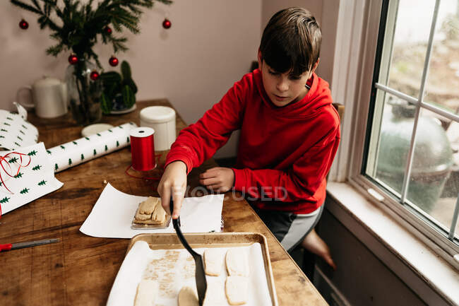 Menino embrulhando biscoitos que ele fez para dar — Fotografia de Stock