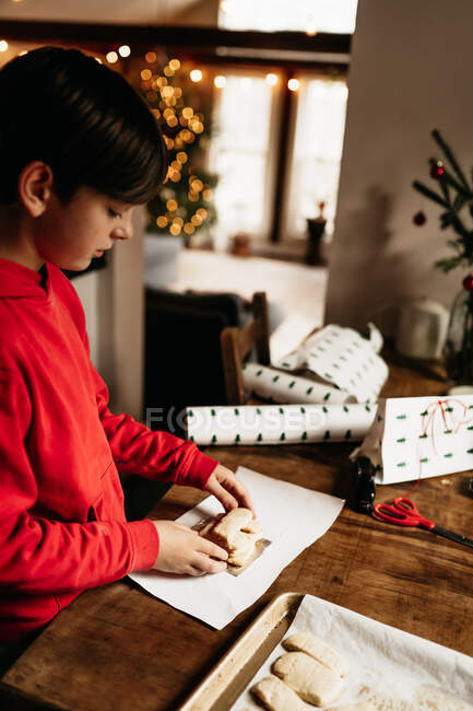 Мальчик упаковывает печенье, готовое к подарку на Рождество — стоковое фото