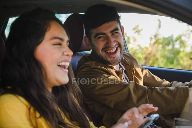 Menina bonita e homem viajando juntos em uma viagem de carro enquanto dirige — Fotografia de Stock