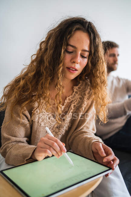 Young designer drawing on tablet near boyfriend — Stock Photo