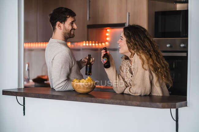 Young couple enjoying beer and chips — Stock Photo