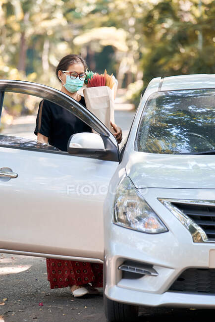 Mulher segura um saco de papel após fazer compras durante a pandemia de COVID-19 — Fotografia de Stock