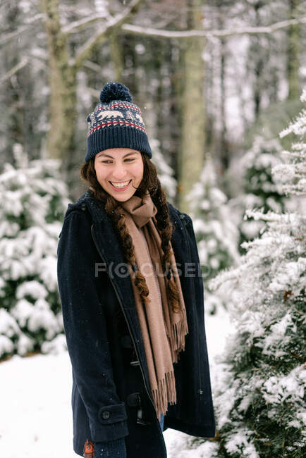 Ritratto di giovane donna con cappello di lana nella neve — Foto stock