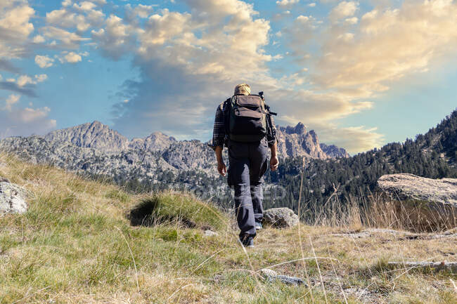 Hombre de mediana edad turista caucásico caminando por la montaña Pirineos Españoles durante el día soleado - foto de stock