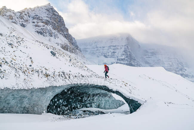 Альпинист карабкается по ледяной пещере на проспекте Айсфилд — стоковое фото