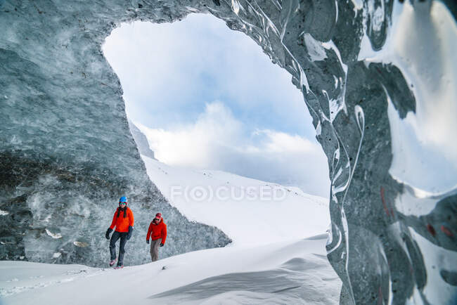 Pareja explorando el interior de los glaciares en la pista de hielo - foto de stock