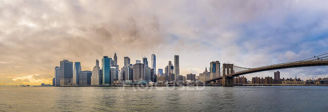 Ultraamplia vista panorámica de Manhattan desde Brooklyn con cielo nublado - foto de stock