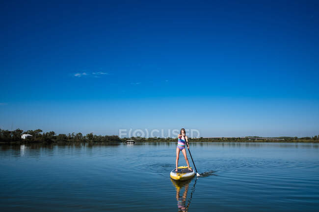 Girl paddleboarding in lake outside of lawrence kansas — Stock Photo