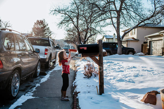 Junges Mädchen steckt Brief in Briefkasten — Stockfoto