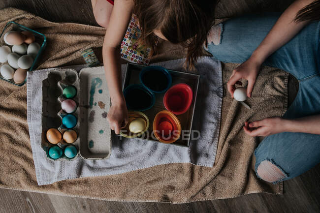 Overhead of siblings dying easter eggs — Stock Photo