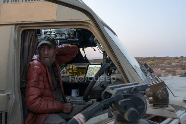 Researcher stands in his vehicle in the namibian desert — Stock Photo