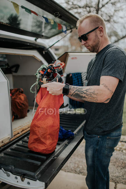 Man putting climbing harness in gear bag — Stock Photo