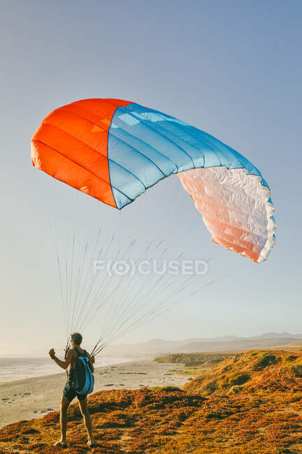 Junger Mann beim Gleitschirmfliegen am Strand der Pazifikküste in Baja, Mexiko — Stockfoto