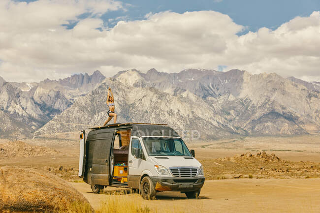 Жінка практикує йогу на даху фургона для кемпінгу в північній Каліфорнії. — стокове фото
