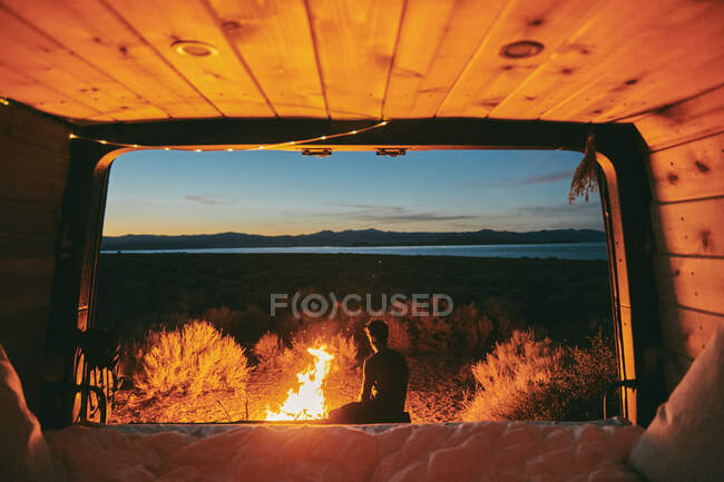 Jovem pela fogueira em Mono Lake à noite no norte da Califórnia — Fotografia de Stock