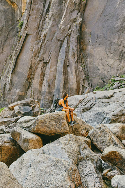 Jovem descansando em pedra, observando Yosemite Falls — Fotografia de Stock