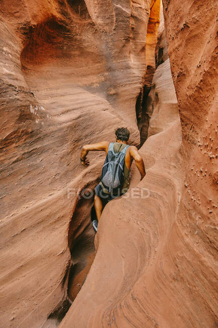 Молодий чоловік, досліджуючи вузькі каньйони в Ескаланте влітку. — стокове фото