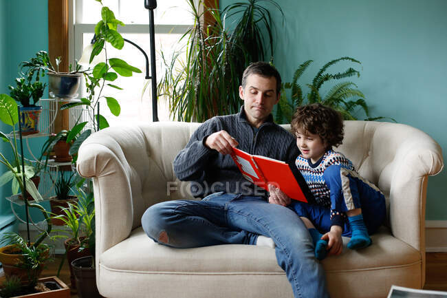 Un padre e un figlio che leggono a casa — Foto stock