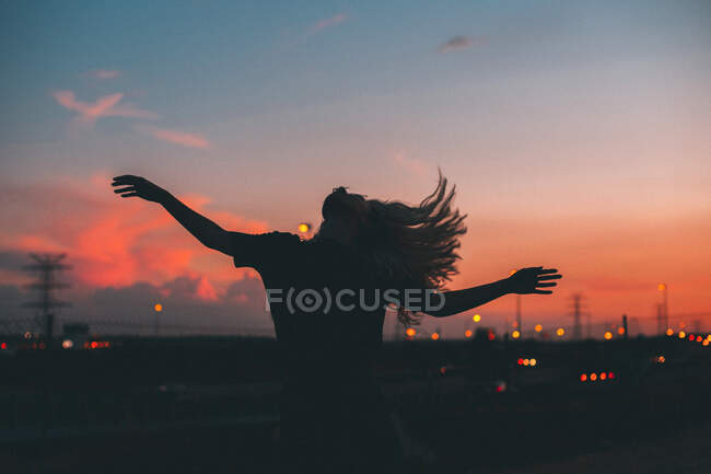 Front view of a woman with arms outstretched blue hour — Stock Photo