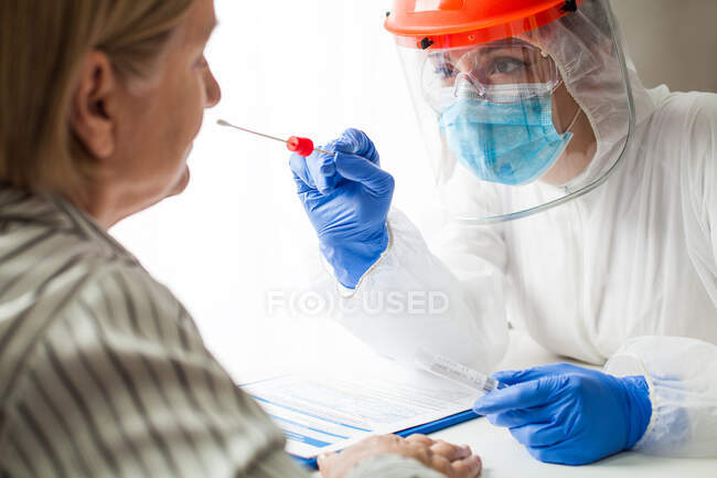 Лікар в особистому захисному спорядженні виконує коронавір. — стокове фото