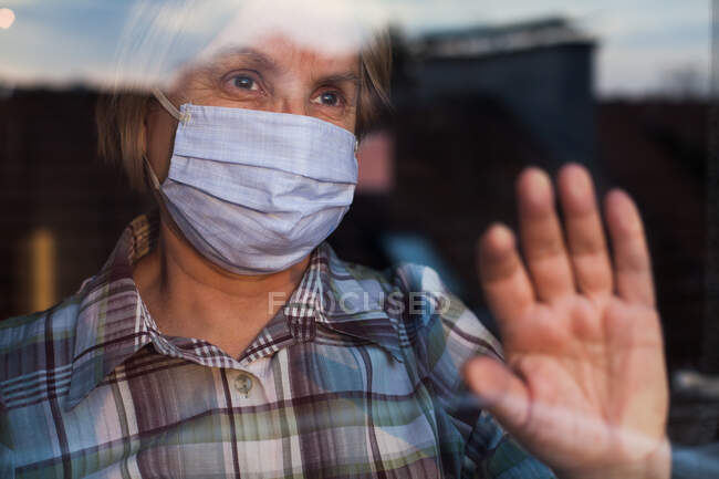 Elderly caucasian woman wearing hand made protective face mask, in nur — Stock Photo