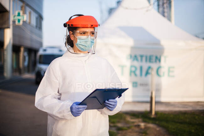 Парамедик носит средства индивидуальной защиты PPE холдинг папку sta — стоковое фото