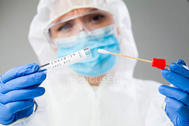 Tecnólogo médico que sostiene el kit de recolección de hisopos COVID-19, - foto de stock