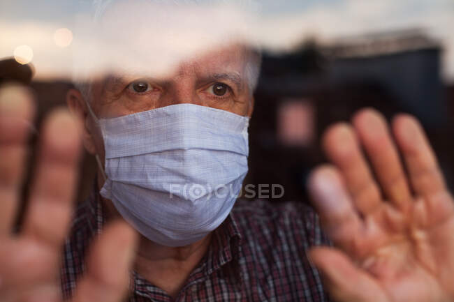 Hombre caucásico de edad avanzada con máscara facial protectora hecha a mano, en nursin - foto de stock