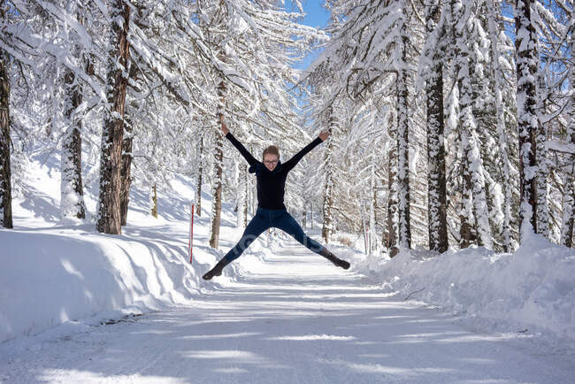 Glückliche junge Frauen springen auf die verschneite Straße — Stockfoto