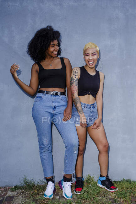 Retrato de duas belas e alegres mulheres jovens de pé juntas — Fotografia de Stock