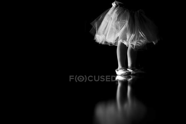 Маленькая девочка играет и танцует балет в пачке и балетной обуви — стоковое фото